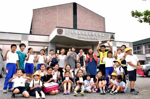 長野初中オモニ会が作るチョゴリタンブラーとノートは子どもたちにも人気。製品を手に記念撮影