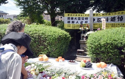 追悼碑に花を手向ける参加者