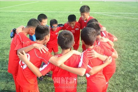 試合前に円陣を組む朝鮮学校と平壌国際サッカー学校の選手ら